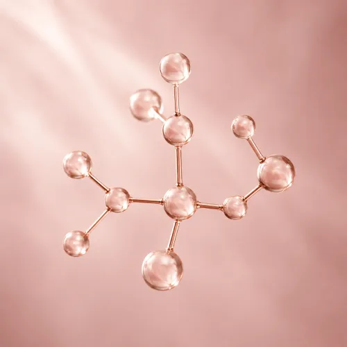 A rose-gold ball-and-stick molecular model suspended against a soft pink background